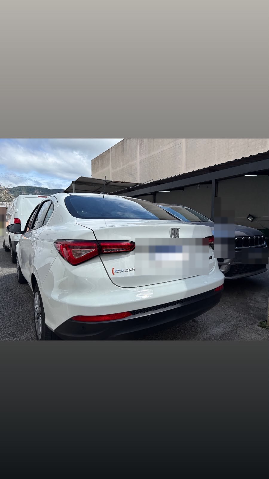 Sedã branco com a pintura limpa e brilhante na entrada da oficina