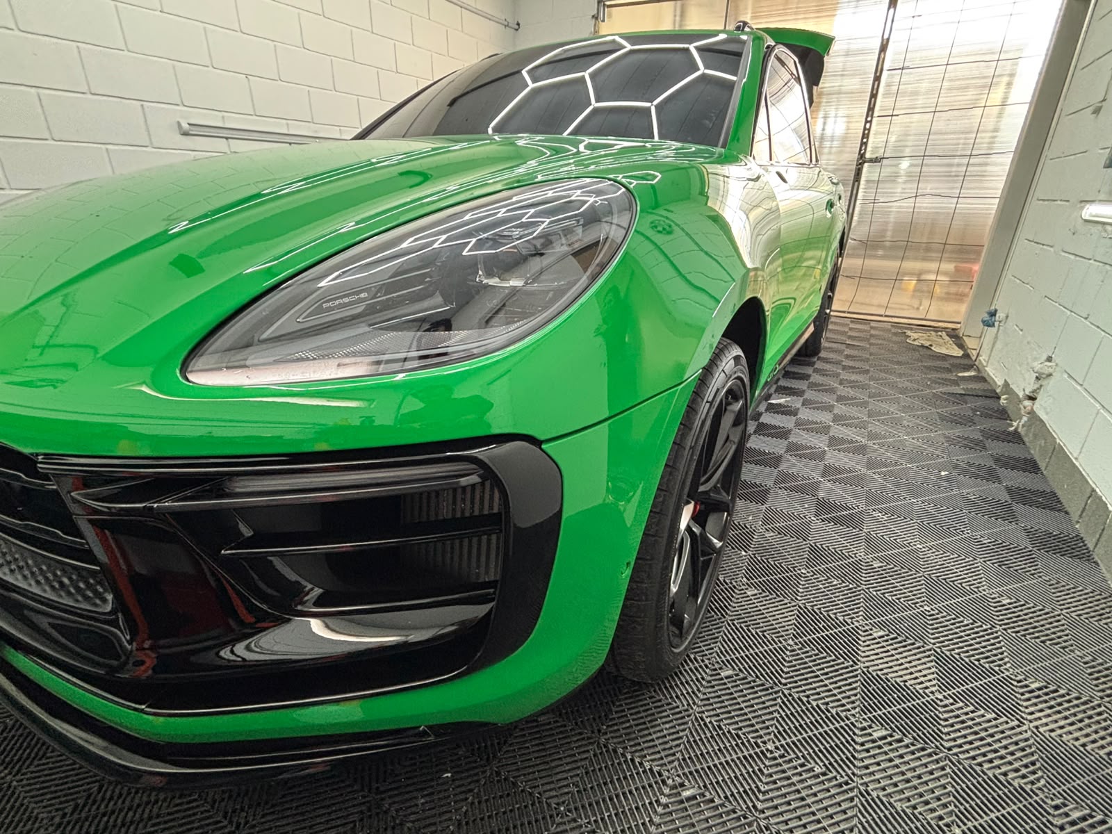 SUV esportiva verde com a pintura brilhante na cabine de luzes hexagonais