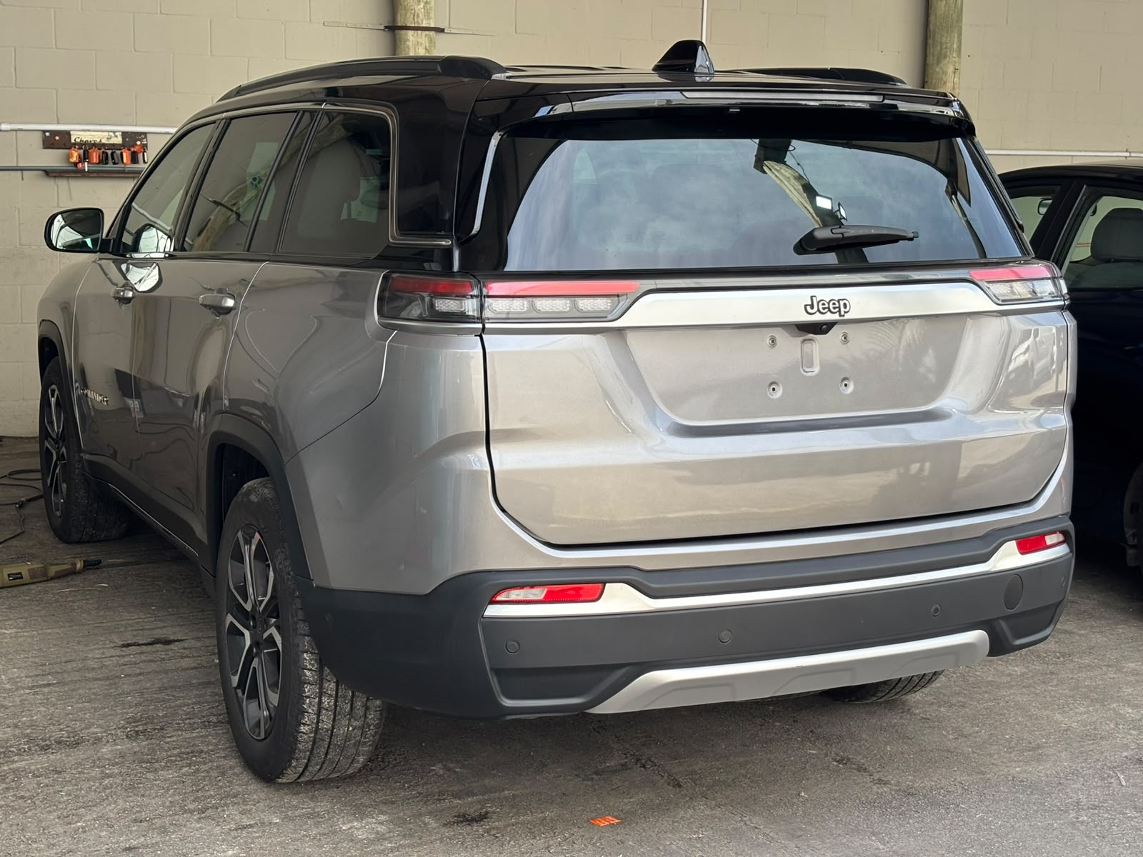 SUV prateada com teto preto no box de detalhamento